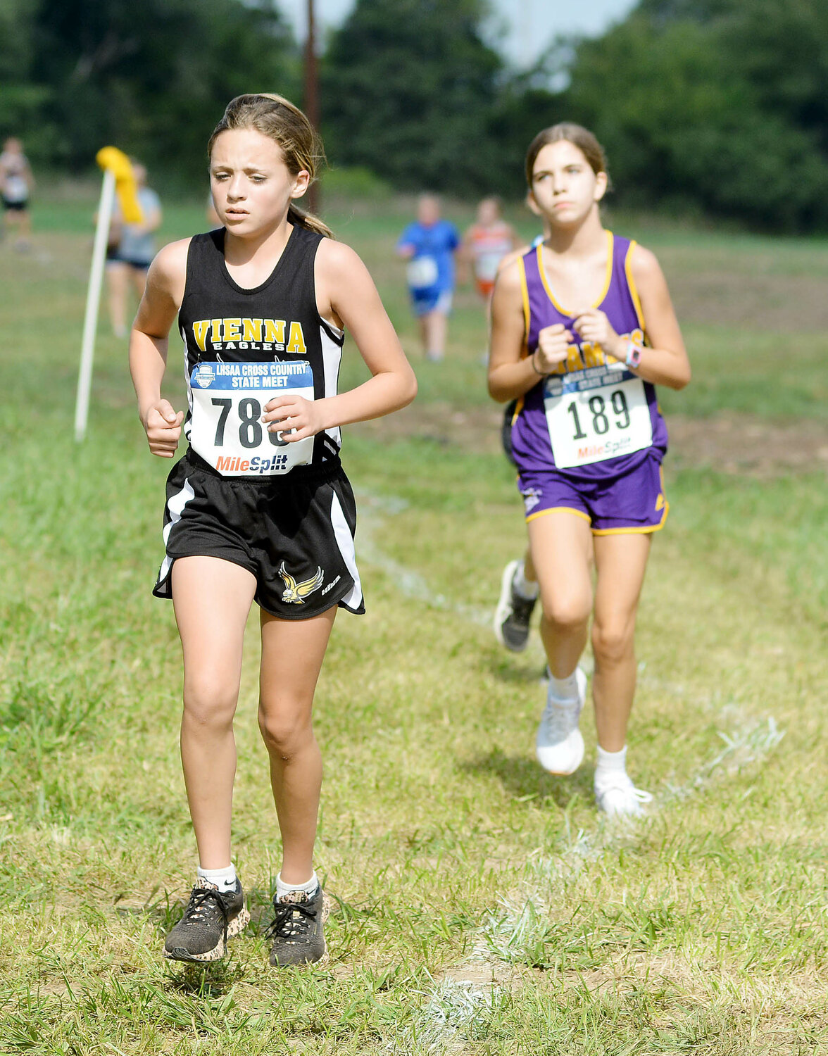 Sophia Neubert (left) stays ahead of Chamois’ Jaelyn Thoenen during the middle school girls race.
